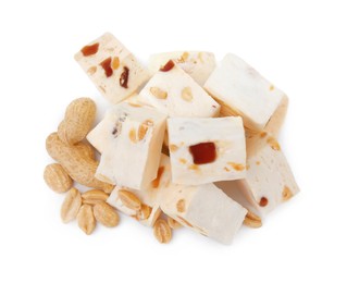 Photo of Pieces of delicious nougat and nuts on white background, top view