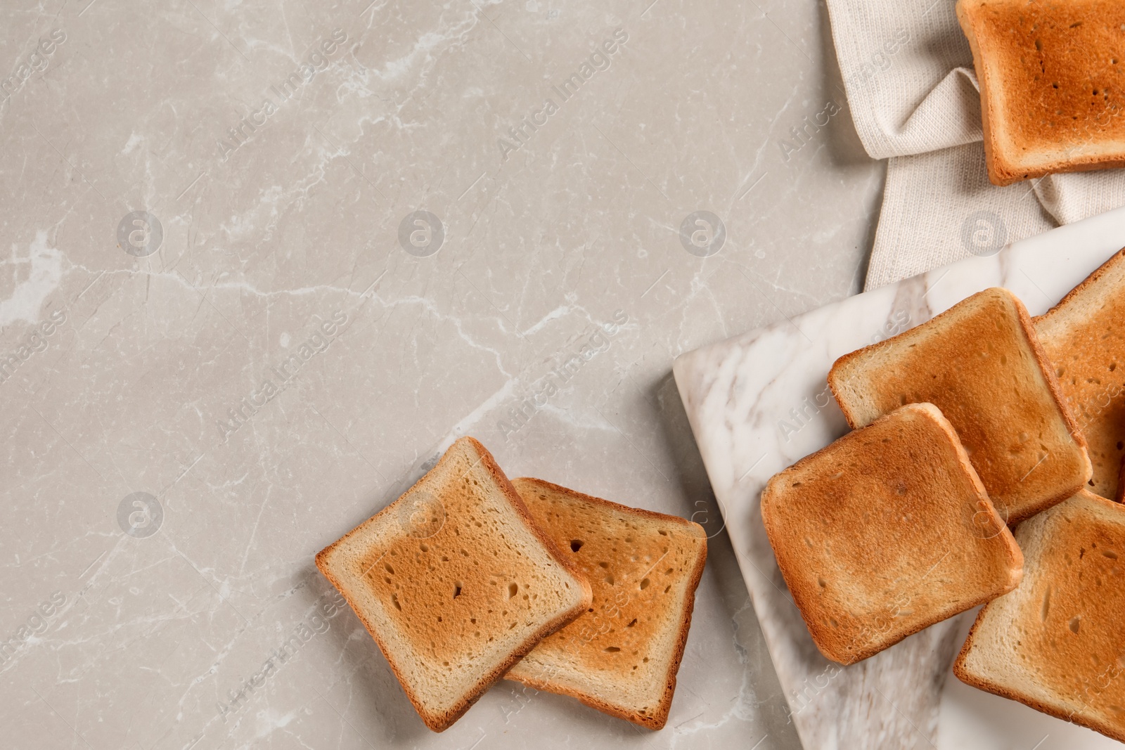 Photo of Slices of delicious toasted bread on gray marble table, flat lay. Space for text