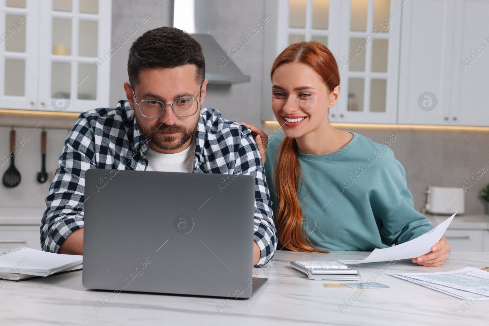 Photo of Couple using laptop for paying taxes at home