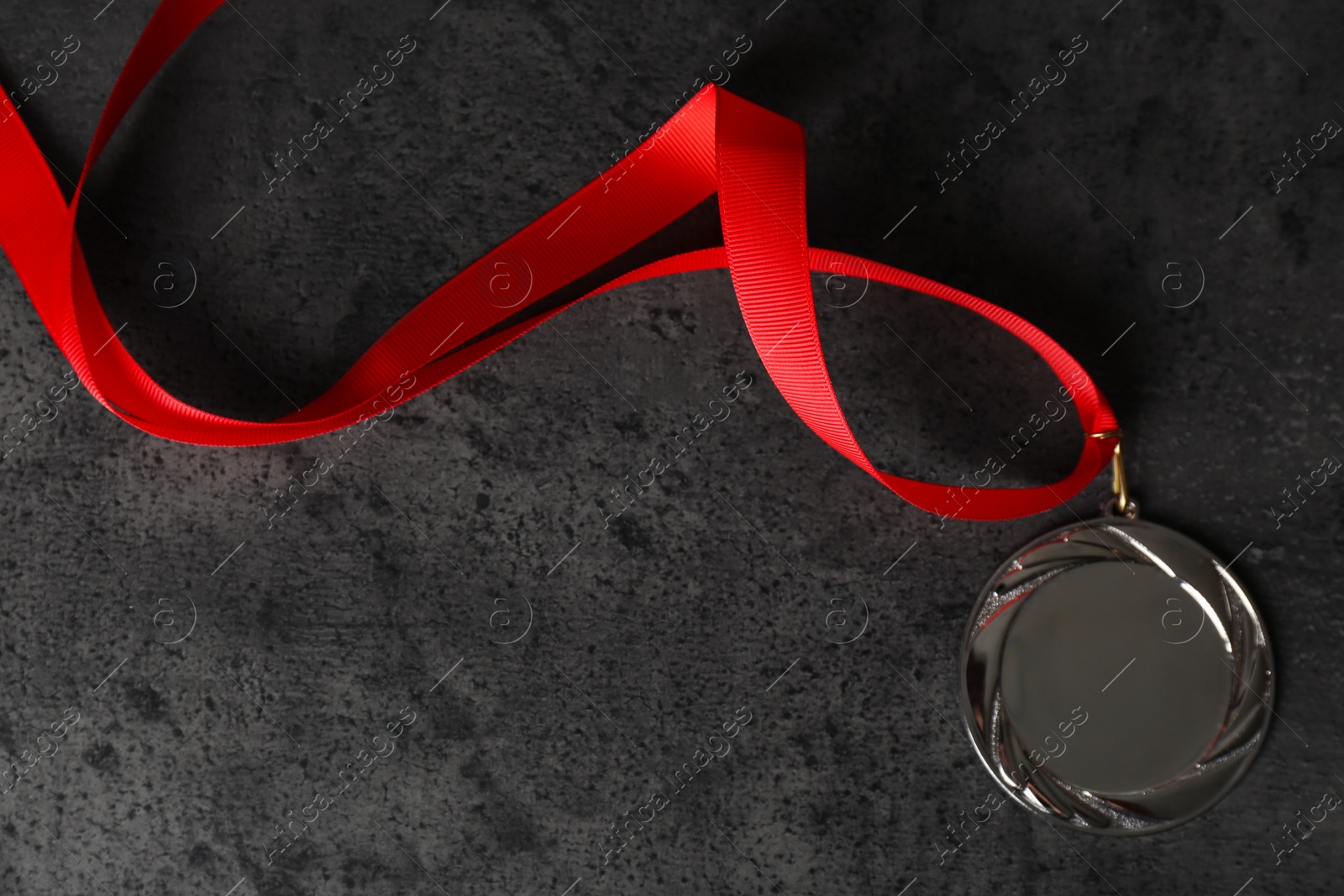 Photo of Silver medal on grey stone background, top view. Space for design