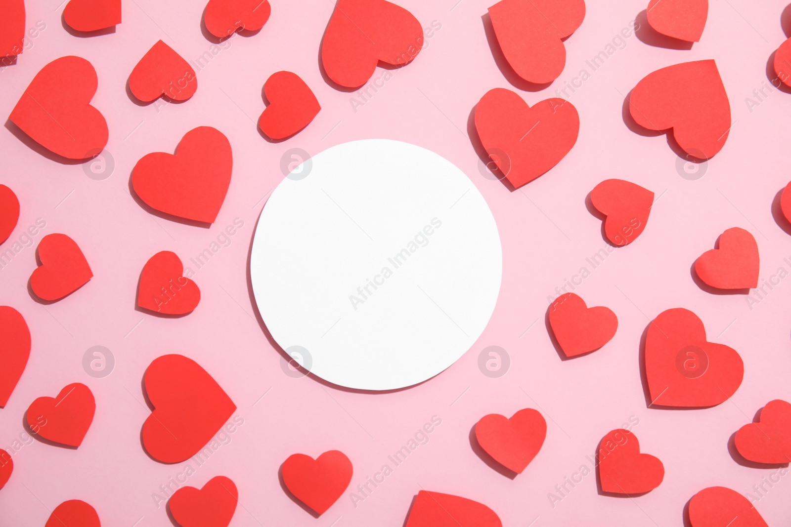 Photo of Small paper hearts and blank card on color background