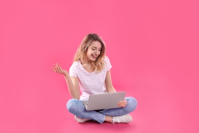 Woman using laptop for video chat on color background