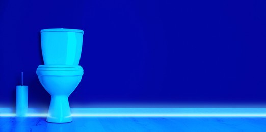 Image of Toilet bowl in public restroom lit with UV blue light