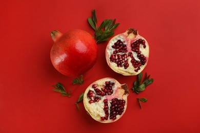 Photo of Flat lay composition with ripe pomegranates on red background