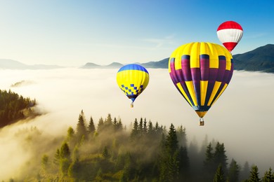 Image of Hot air balloons flying over foggy mountains