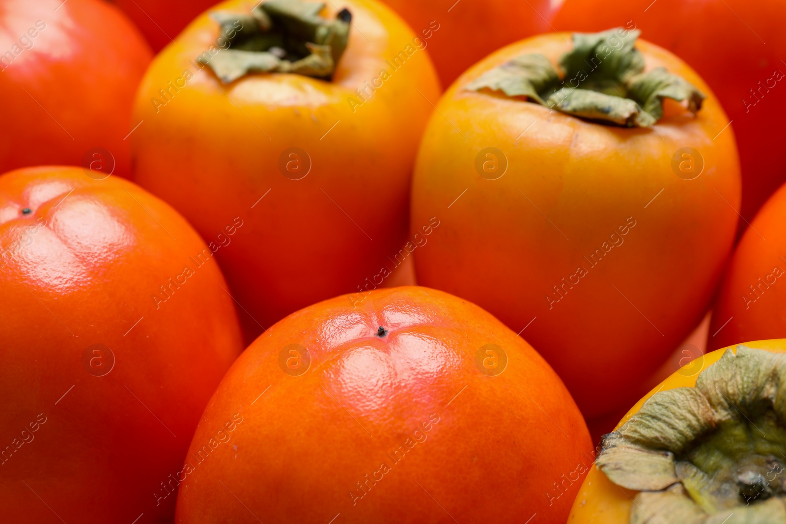 Photo of Delicious ripe juicy persimmons as background, closeup