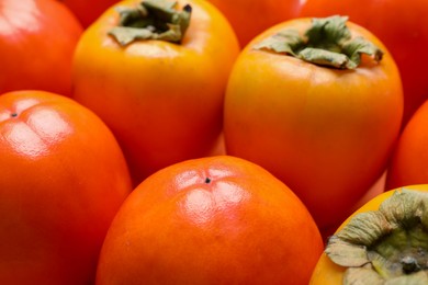 Delicious ripe juicy persimmons as background, closeup