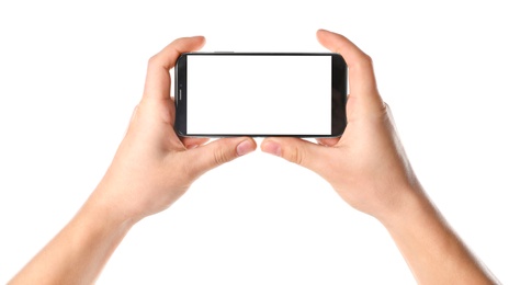 Man holding smartphone with blank screen on white background, closeup of hands. Space for text