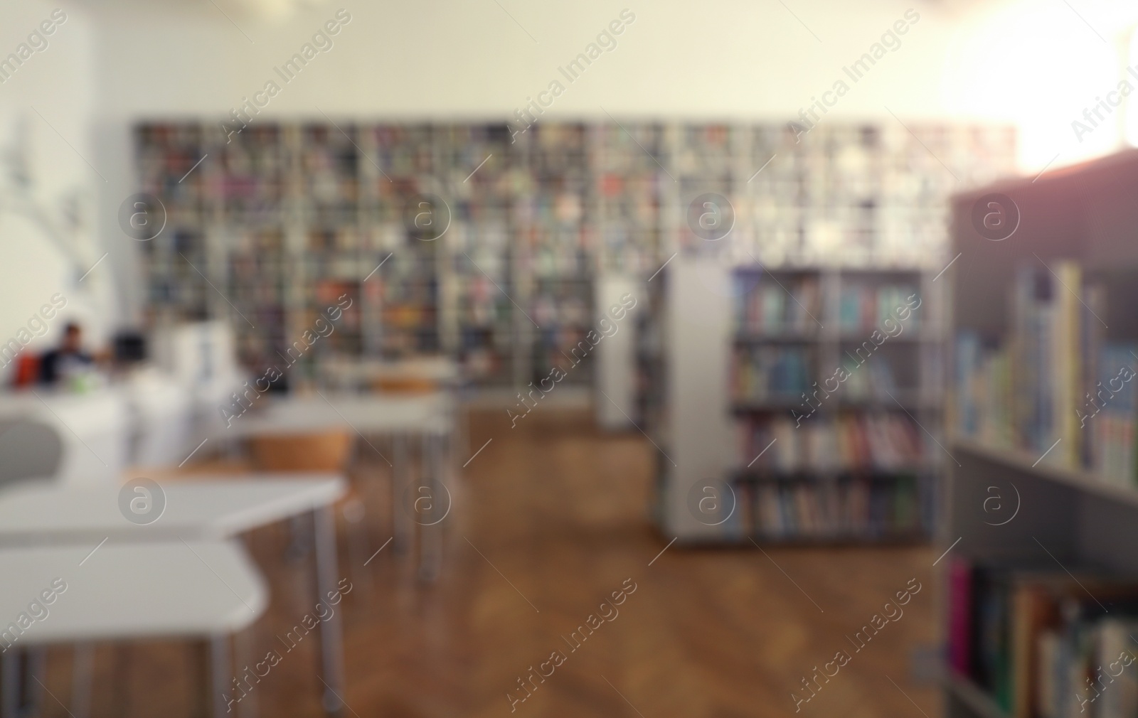 Photo of Blurred view of library interior with bookcases and tables