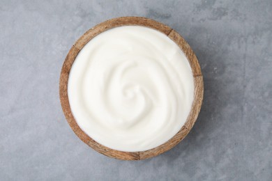 Photo of Delicious natural yogurt in bowl on grey table, top view