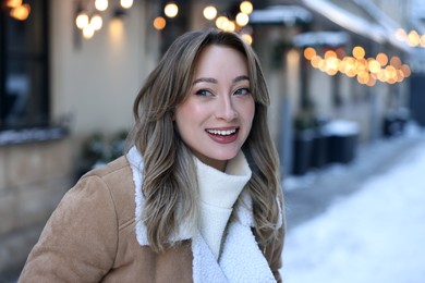 Portrait of happy woman on city street in winter