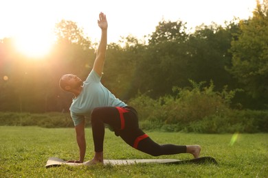 Man practicing yoga outdoors on sunny day