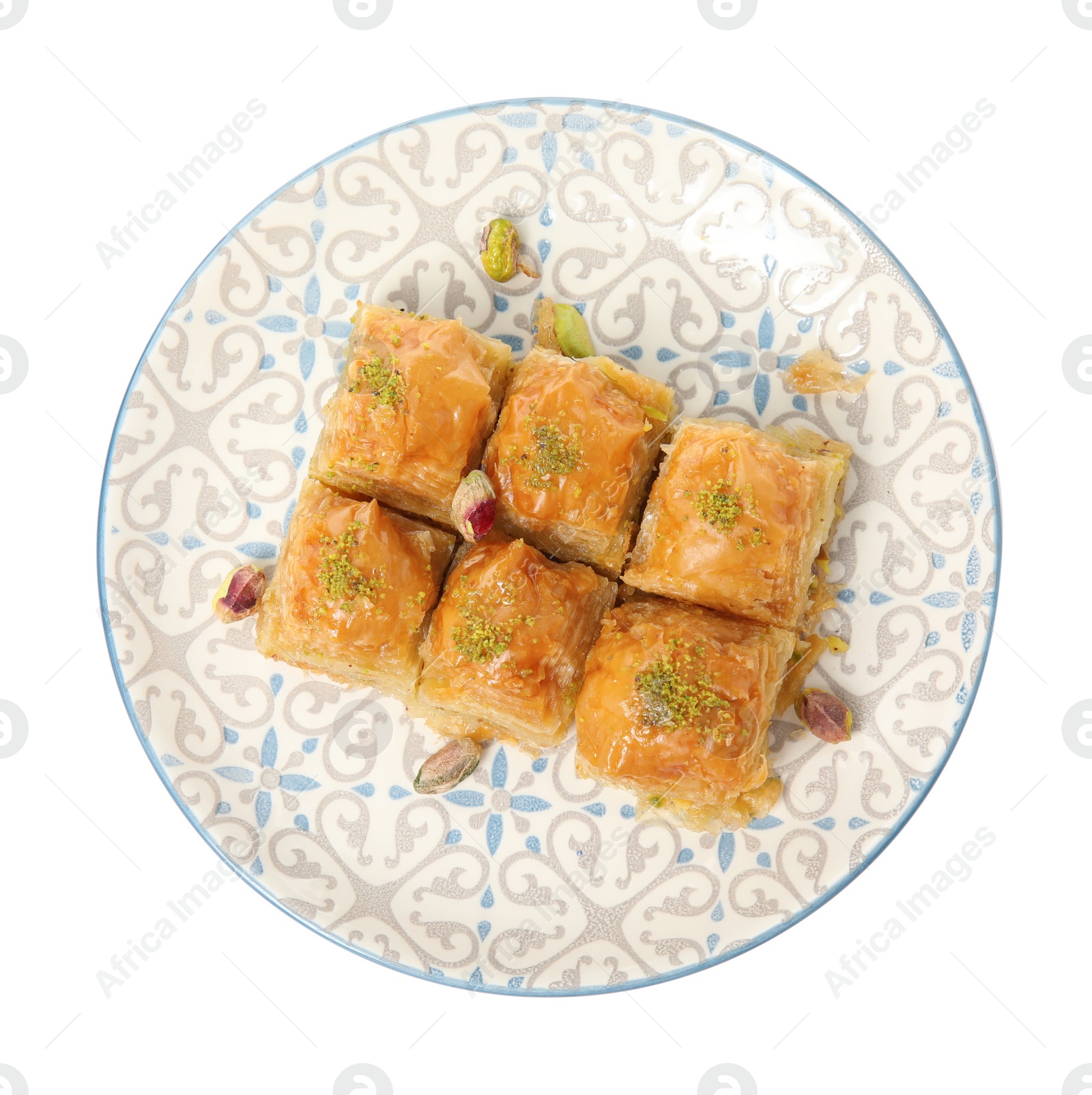 Photo of Plate of delicious baklava with pistachio nuts isolated on white, top view