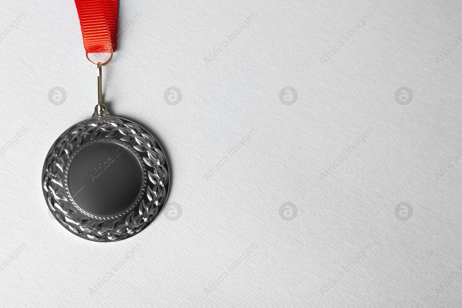 Photo of Silver medal on white background, top view. Space for design