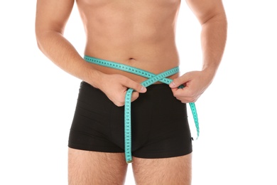 Photo of Fit man measuring his waist on white background, closeup. Weight loss