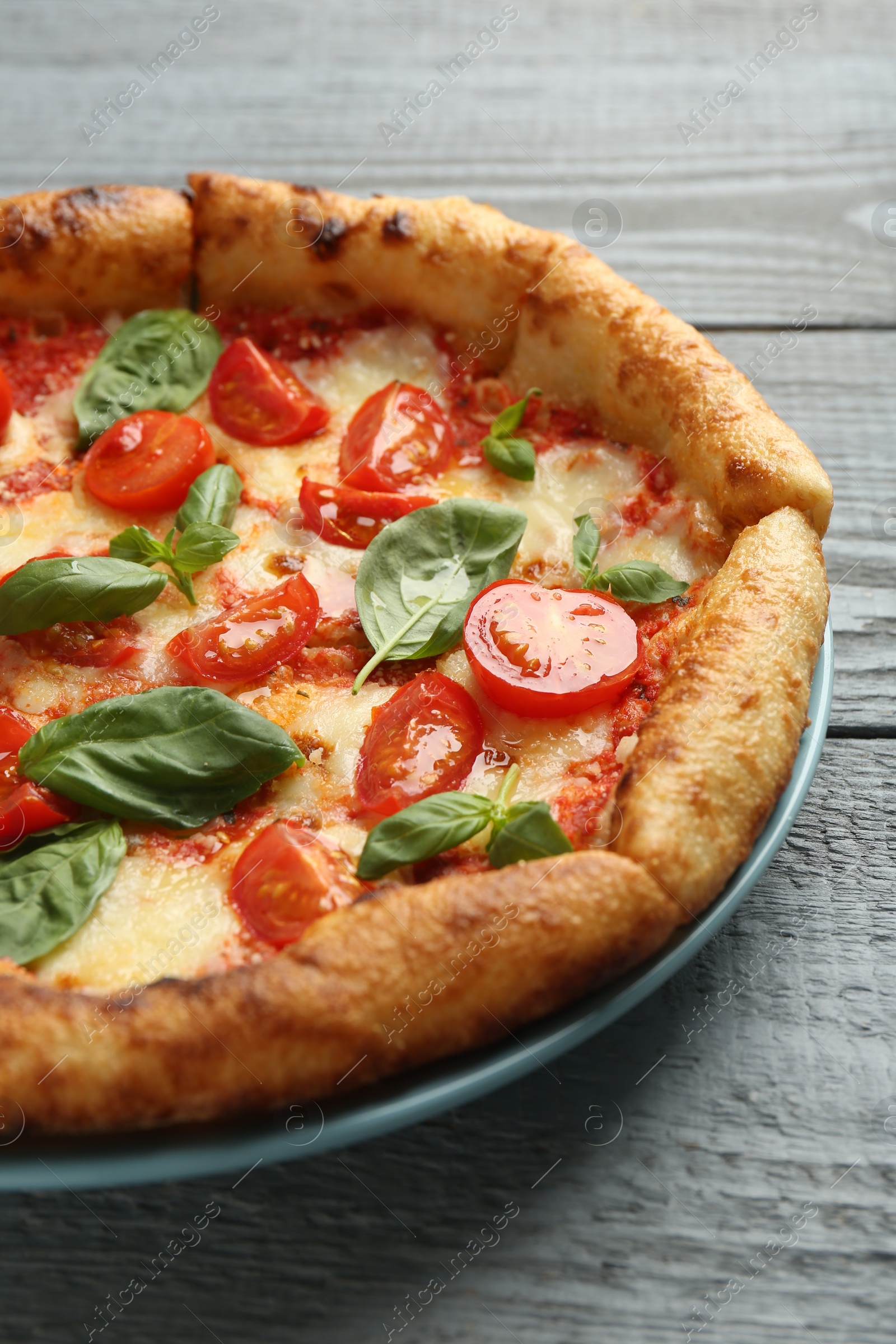 Photo of Delicious Margherita pizza on gray table, closeup