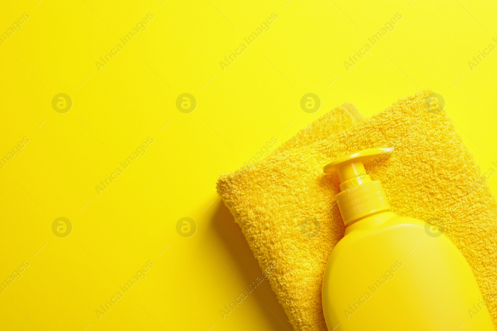 Photo of Towel and lotion on color background, top view with space for text. Beach accessories