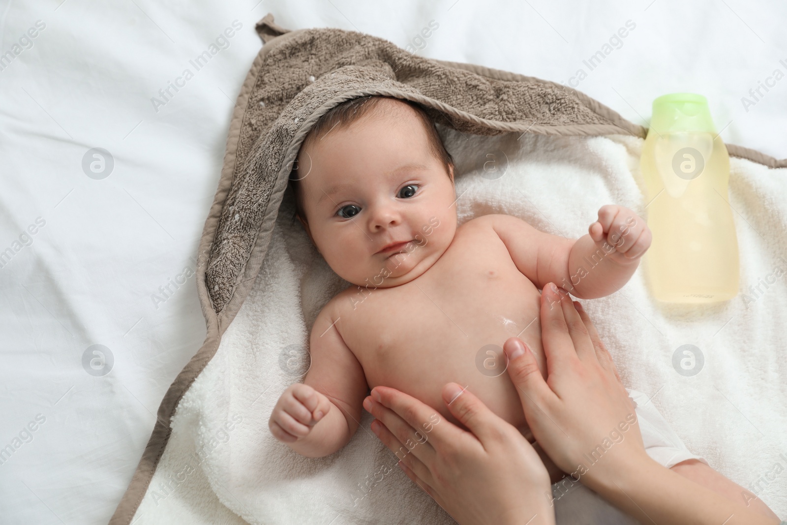 Photo of Mother massaging her cute baby with oil, closeup