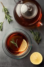 Aromatic herbal tea with rosemary and lemon on grey table, flat lay