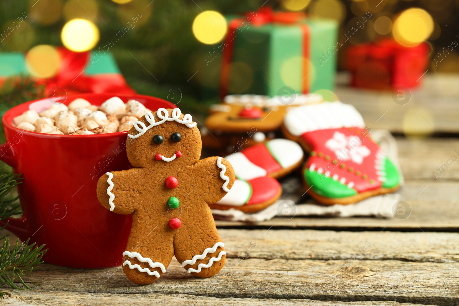 Photo of Tasty gingerbread man cookie and cocoa with marshmallows on wooden table. Space for text