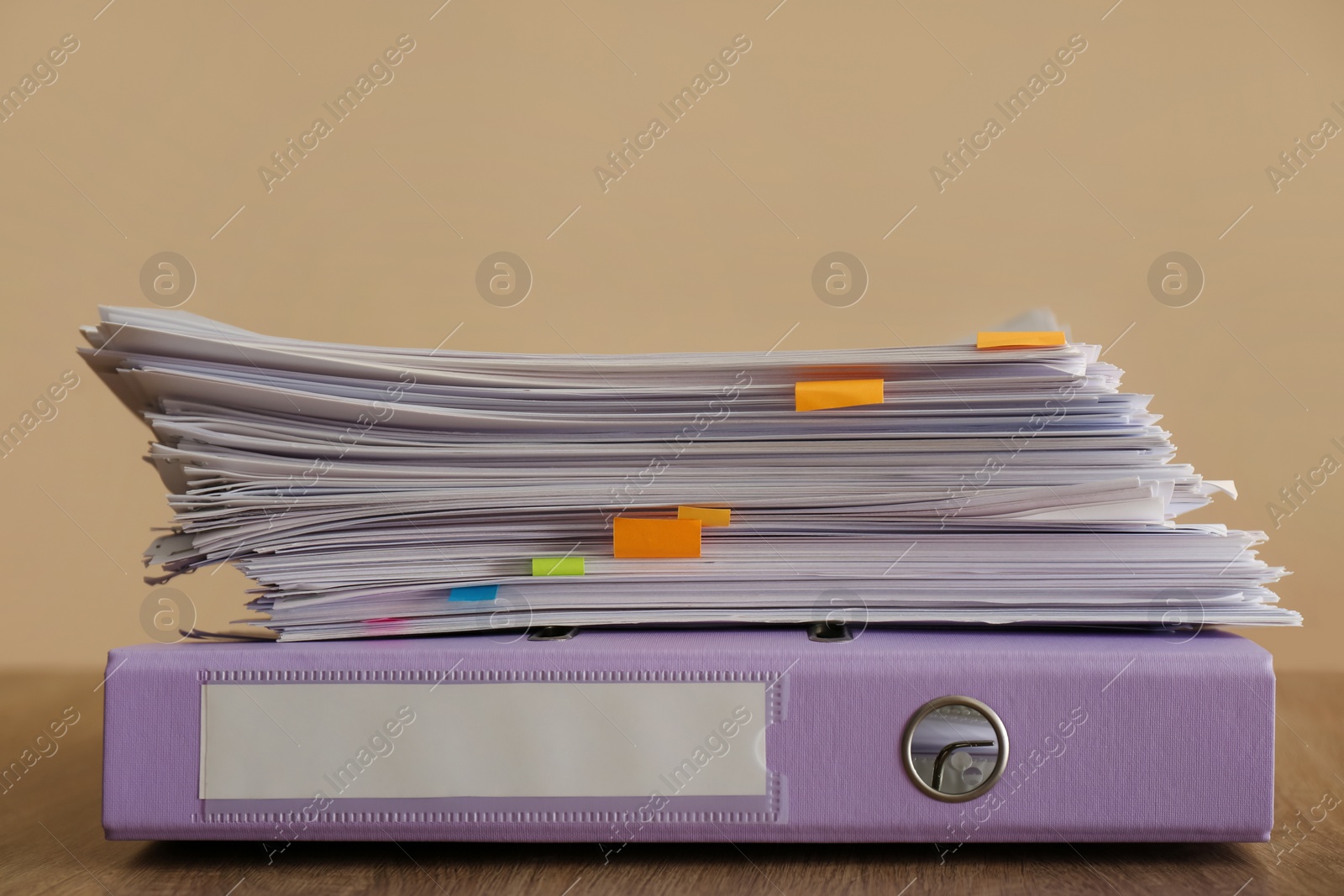 Photo of Stack of documents and office folder on wooden table against brown background
