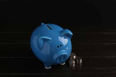 Financial savings. Piggy bank and coins on wooden table
