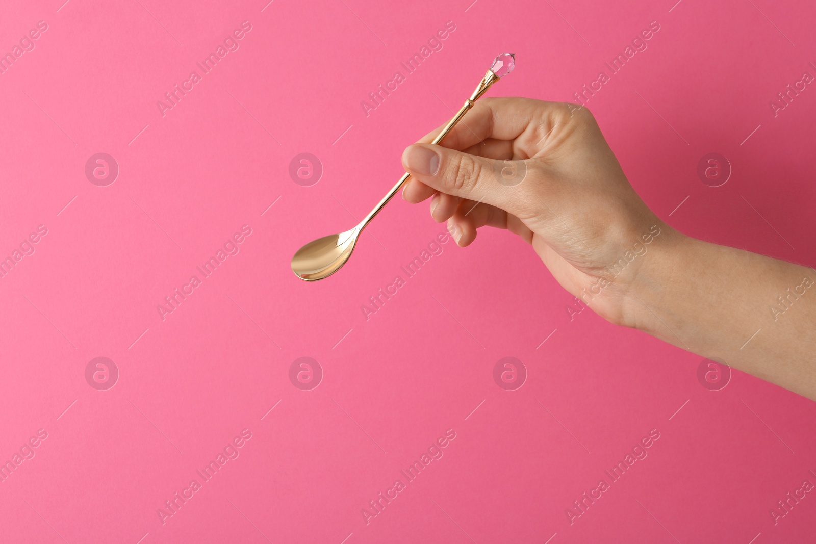 Photo of Woman holding empty teaspoon on color background, closeup. Space for text