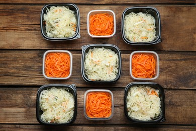 Photo of Plastic containers with tasty vegetable salads on wooden table, flat lay. Food delivery service