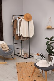 Rack with stylish women's clothes and shoes in dressing room