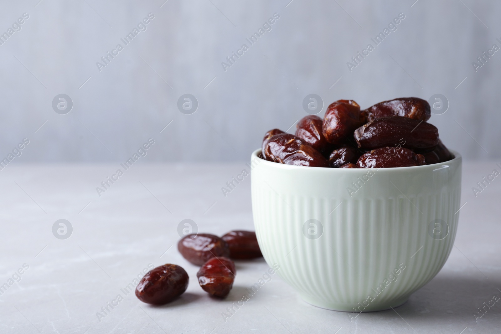 Photo of Bowl with sweet dates on table, space for text. Dried fruit as healthy snack