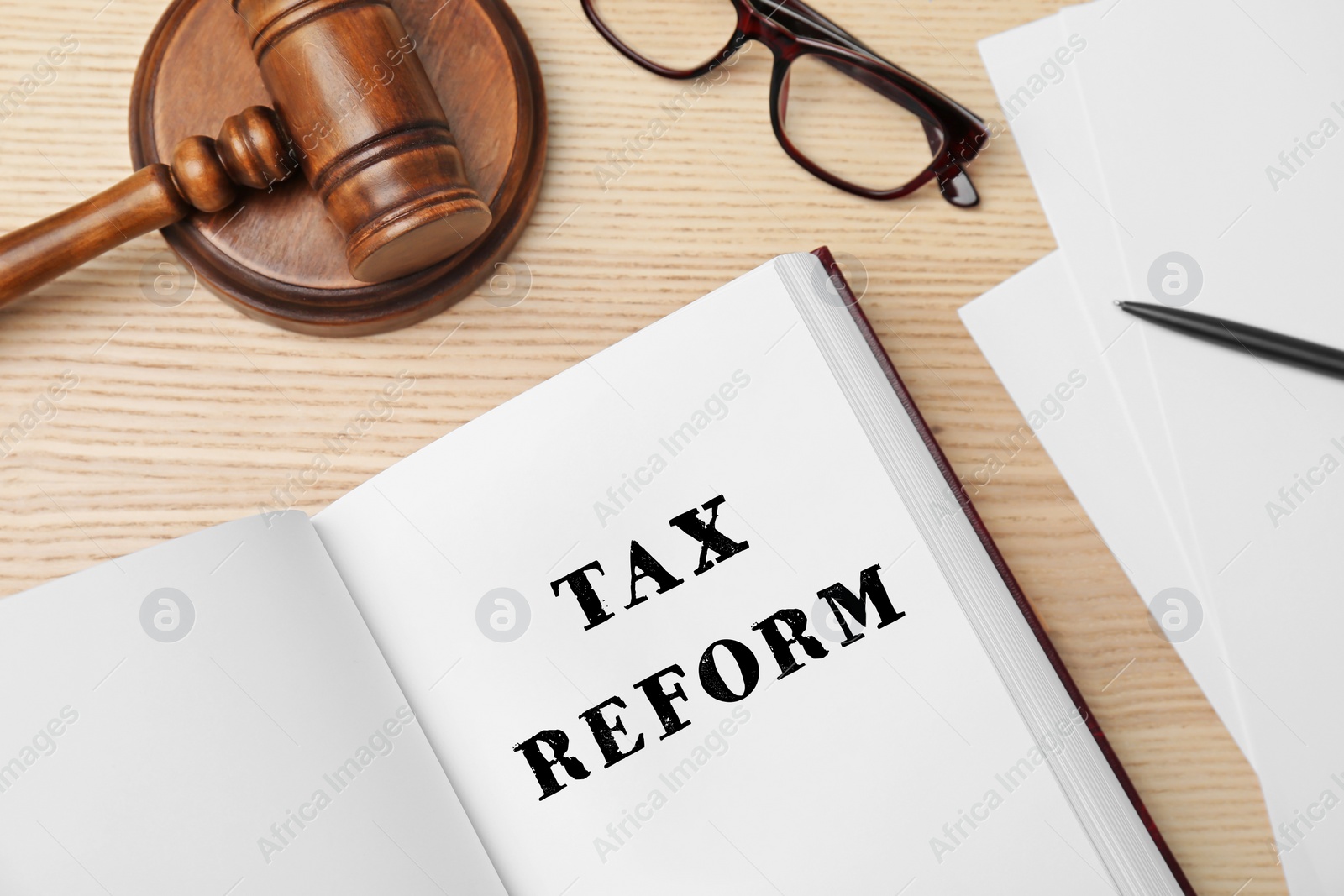 Image of Book with text TAX REFORM, gavel and glasses on wooden background, flat lay