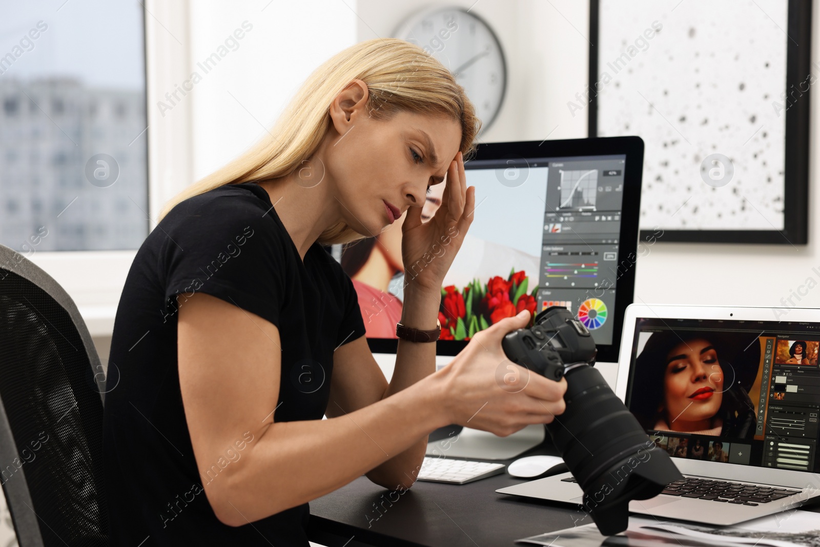 Photo of Professional photographer with digital camera at table in office