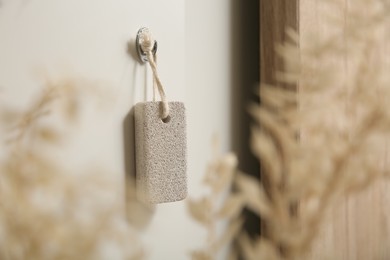 Photo of Pumice stone hanging on white wall indoors
