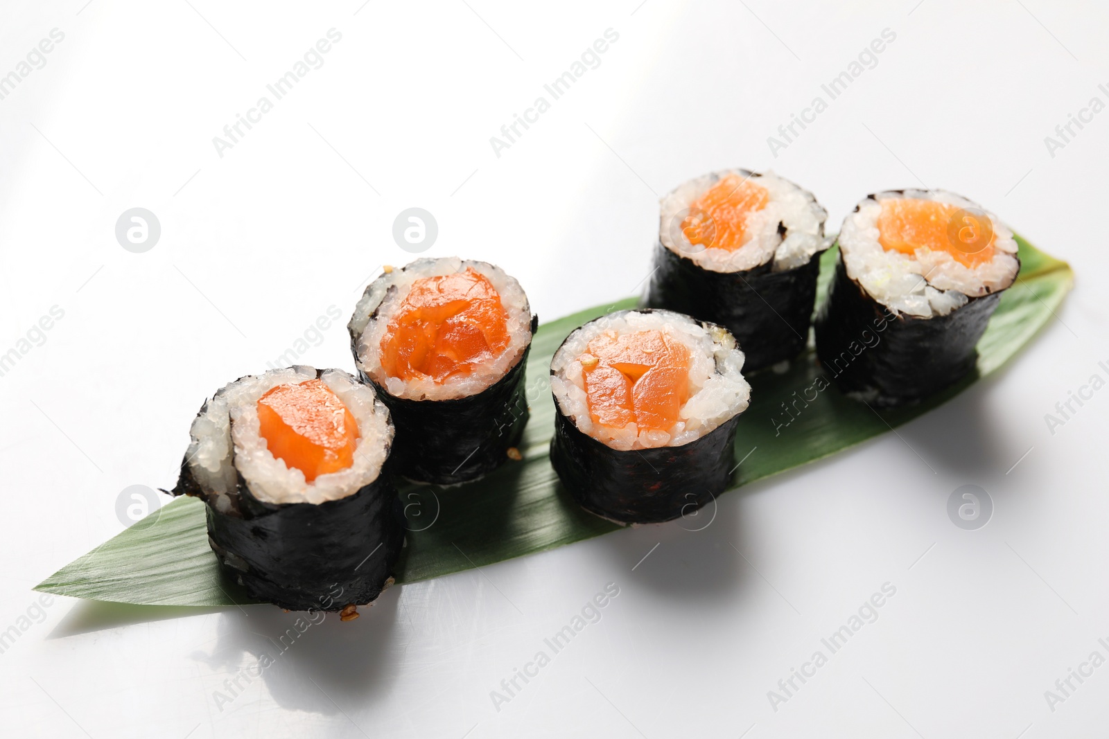 Photo of Delicious sushi rolls with salmon on white background