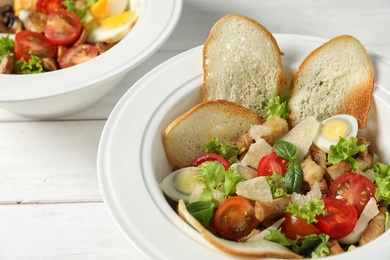 Photo of Plate with delicious fresh salad on table, closeup