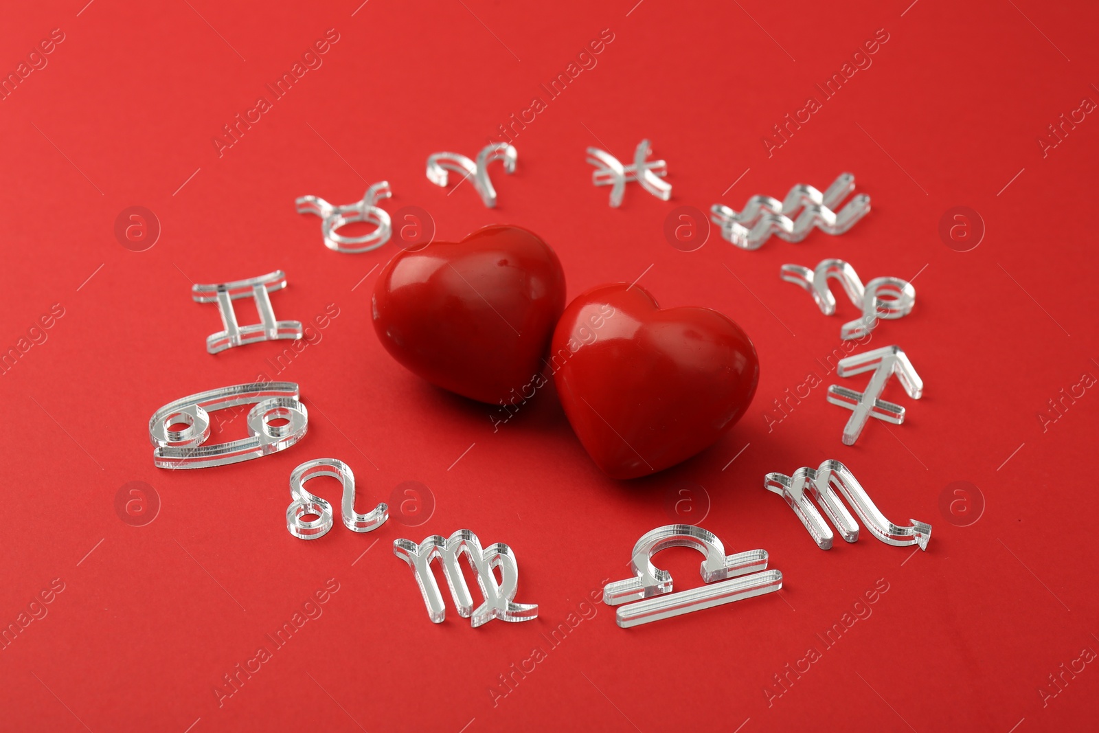 Photo of Zodiac signs and hearts on red background