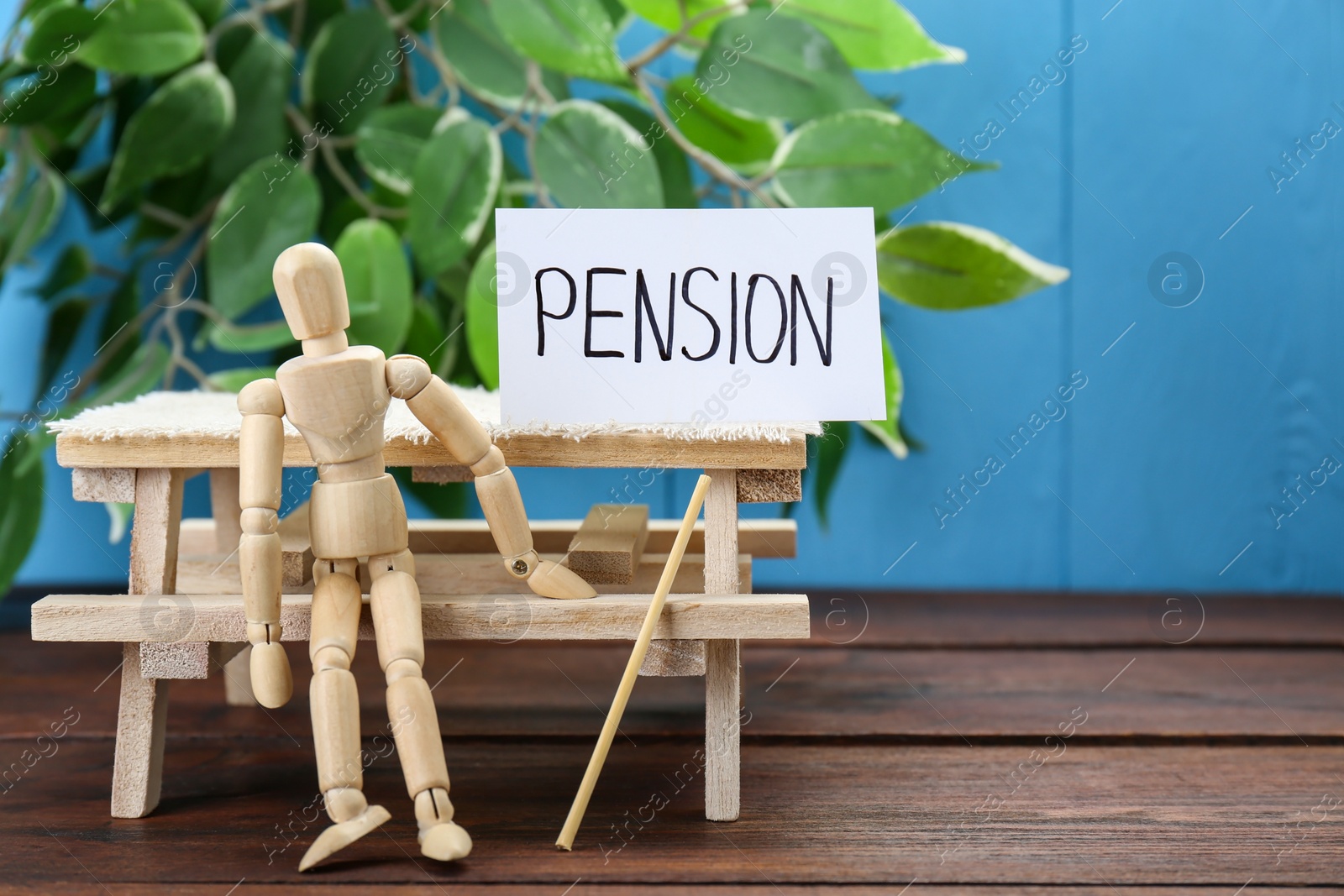 Photo of Card with word Pension and wooden human figure on table, space for text. Retirement concept