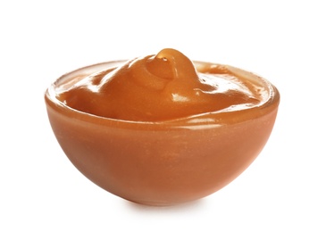Photo of Bowl of tasty caramel sauce isolated on white