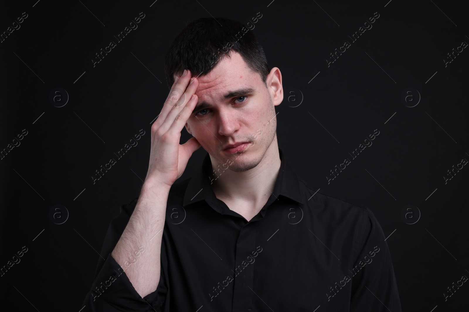 Photo of Portrait of sad man on black background