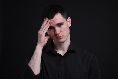 Photo of Portrait of sad man on black background