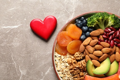 Photo of Plate with heart-healthy products on grey background, top view. Space for text
