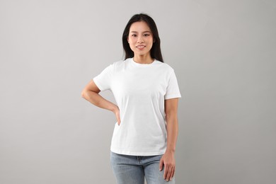 Photo of Woman wearing white t-shirt on light grey background