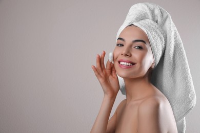 Photo of Woman using silkworm cocoon in skin care routine on light grey background. Space for text