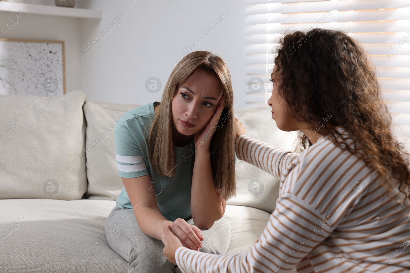 Photo of Unhappy young woman having session with her therapist indoors