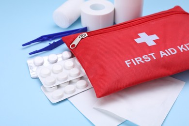 Photo of First aid kit on light blue background, closeup