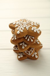 Photo of Stack of tasty Christmas cookies with icing on white wooden table