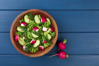 Delicious radish salad and ingredients on blue wooden table, top view. Space for text