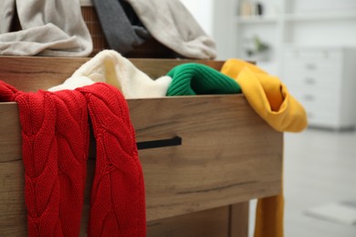 Photo of Cluttered chest of drawers indoors, closeup. Clothes in mess