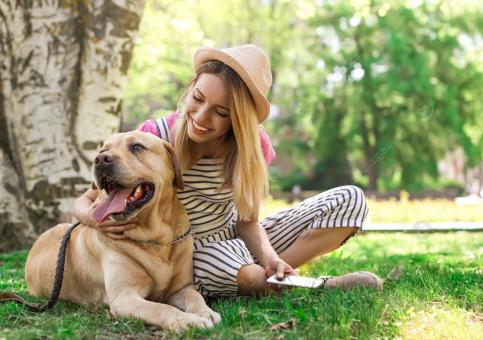 Photo of Young woman and her dog spending time together outdoors. Pet care