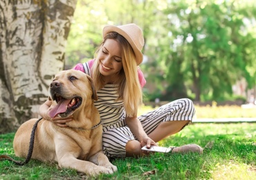 Young woman and her dog spending time together outdoors. Pet care